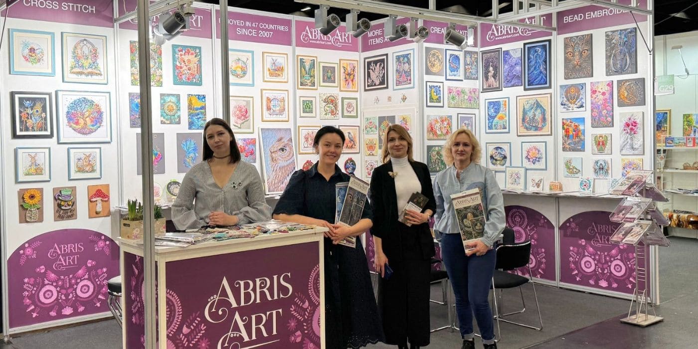 Abris Art stand at an international craft trade show with the company team and its bead and cross stitch embroidery kits